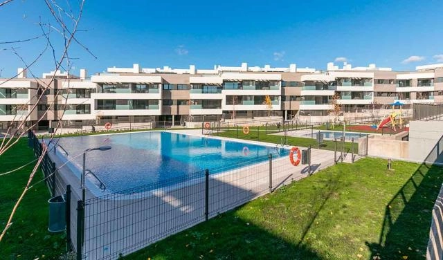 Espectacular vivienda a ESTRENAR en Boadilla del Monte. Residencial NACARI de Via Célere. SEGUNDO Piso totalmente Exterior de DOS dormitorios DOS baños, con terraza y tendedero de 96 metros cuadrados construidos más trastero de 12 metros cuadrados construidos y UNA plaza de garaje grande (más de 12 metros cuadrados útiles) ubicada frente a la puerta de salida y entrada a las viviendas y trasteros. Acabados de primera calidad. Puerta Acorazada DIERRE y Videoportero. La vivienda tiene la cocina amueblada con horno eléctrico, microondas, lavavajillas integrado y campana Bosh y placa inducción Balay. Encimera SILESTONE. Cuenta con dos baños completos uno con bañera y otro con plato de ducha. Todo del GRUPO PORCELANOSA. Muebles de baño incluidos. Calefacción mediante radiadores y gas. Aire Acondicionado mediante conductos. Aprovechamiento de agua caliente con placas solares (eficiencia energética B). Tarima flotante KronoSwiss de color gris y carpintería interior todo en blanco. Persianas motorizadas en toda la vivienda. La vivienda está totalmente cableada para INTERNET y TDT e incluye cargadores USB en dormitorio principal y salon La urbanización cuenta con unas zonas comunes muy completas con jardines, zona de juegos infantil, con pista de padel de cristal, gimnasio completamente equipado, piscina de adultos e infantil, salas Gourmet - Social y Sala Infantil completamente equipadas. Zona Sector Sur 11 de Boadilla en pleno crecimiento junto a institutos y colegios, zonas comerciales y supermercados y a sólo 5 minutos de Sector B y Avenida Siglo XXI. Perfectamente comunicado mediante transporte público (metro ligero parada “Puerta de Boadilla” y autobuses) y vehículo privado (M50, M516, M511 y M513. Perfecta para parejas con niños o sin ellos. Urbanización Cerrada con garita de Seguridad y control de acceso mediante cámaras.